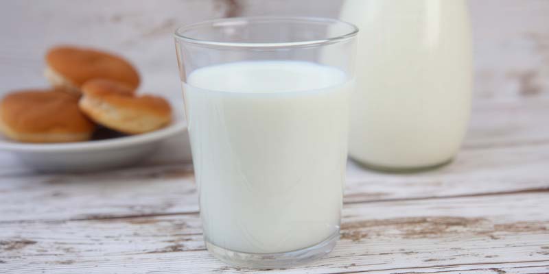 عکس زیبا از لیوان شیشه پر از شیر روی میز