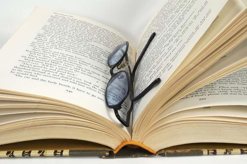 تصویر لارج فرمت از عینک مطالعه وسط کتاب
