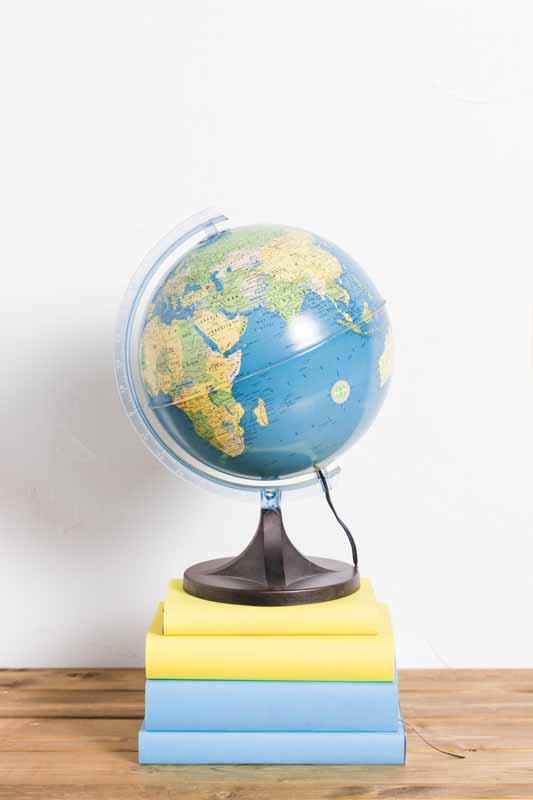 دانلود تصویر باکیفیت کره جغرافیایی روی کتاب