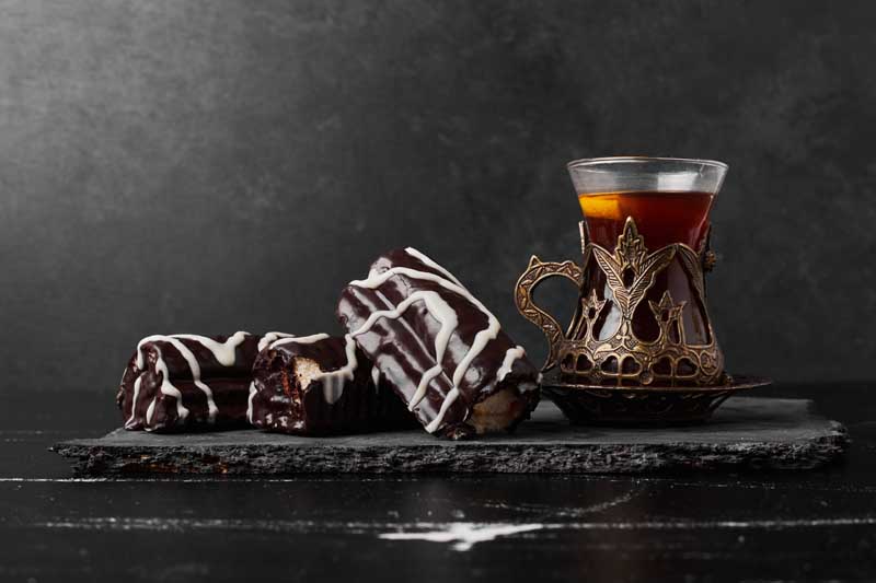 دانلود تصویر شیرینی های شکلاتی و فنجان چای