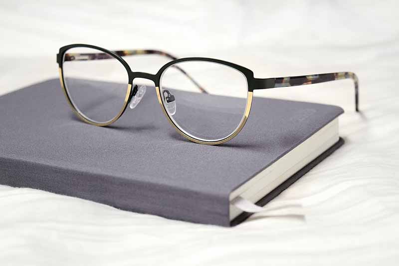 عکس باکیفیت عینک مطالعه فریم پروانه ای با کتاب