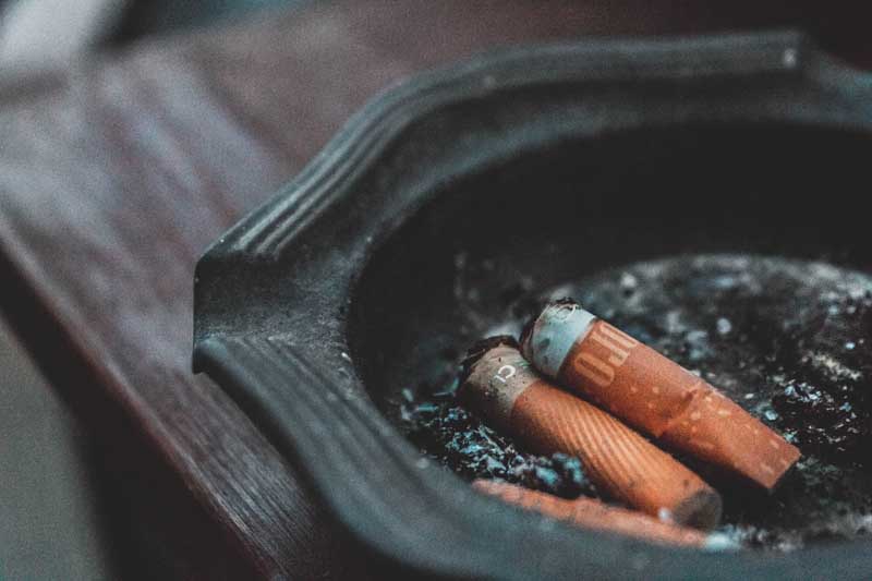 تصویر گرافیکی دو عدد فیلتر سیگار داخل زیر سیگاری