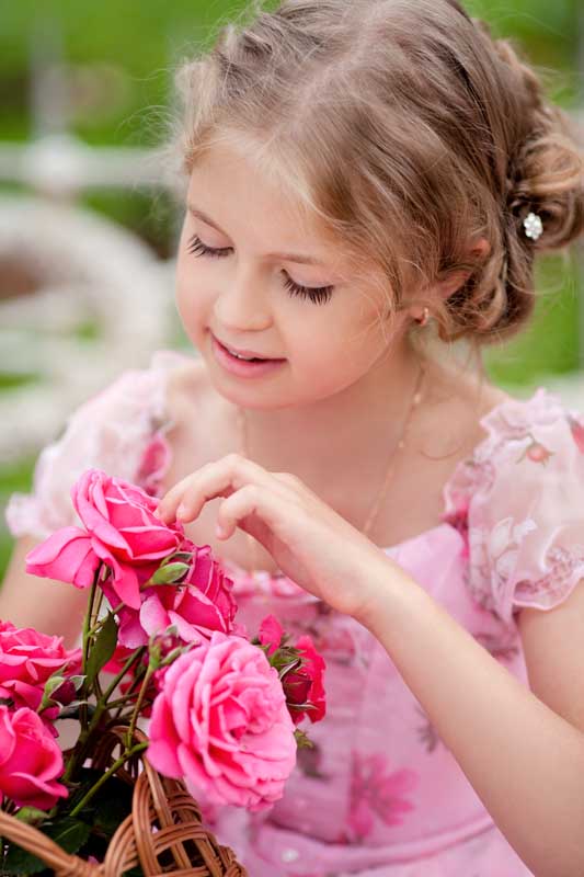 دانلود تصویر با کیفیت دختر بچه در حال نگاه کردن به گل