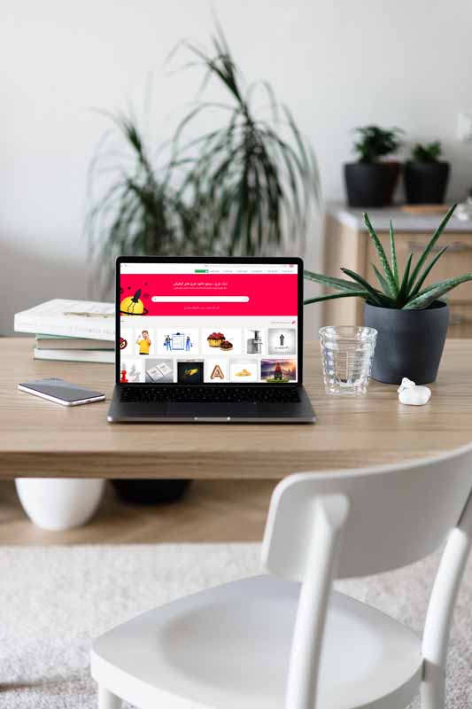 طرح موکاپ لپ تاپ در روی میز چوبی