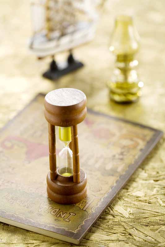 تصویر با کیفیت از ساعت شنی روی کتاب