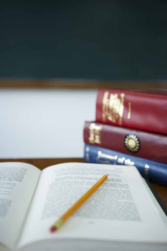 تصویر با کیفیت از مداد زرد روی کتاب